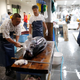 A fishmonger cuts tuna meat at a wholesalers’ area.